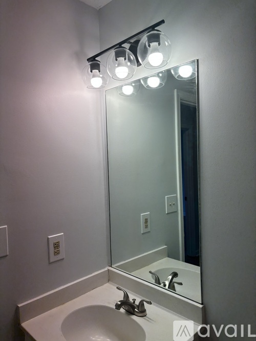 A bathroom sink under a mirror with lights above it.