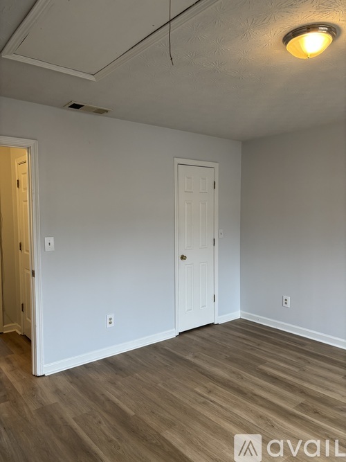 A room with a white door and a light on the ceiling.