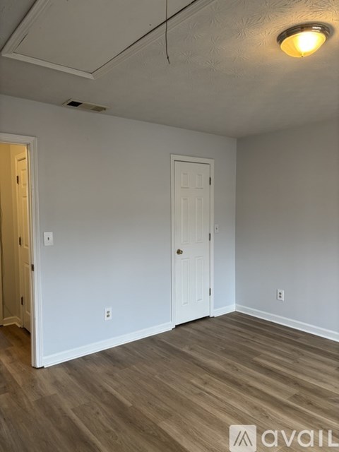 A room with a white door and a light on the ceiling.