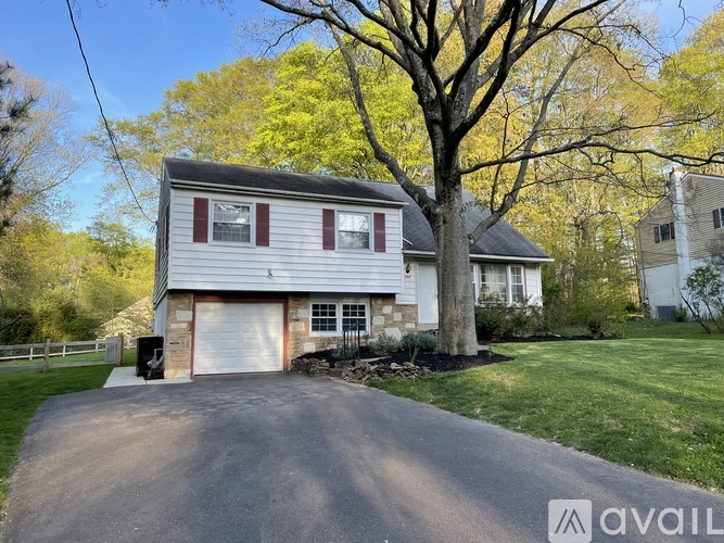 A house with a driveway and a tree in front.