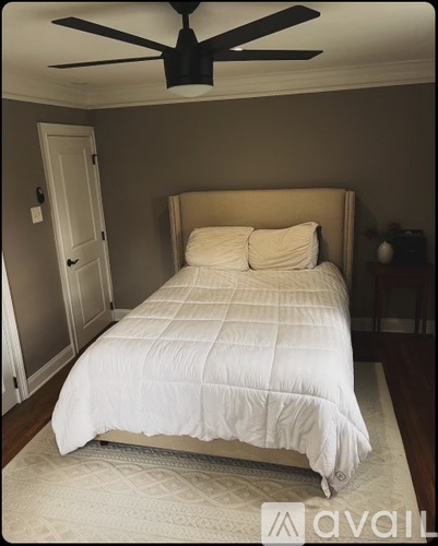 A bedroom with a large bed and a ceiling fan.
