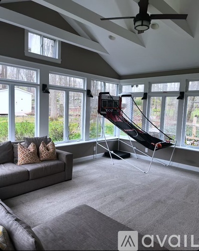 A living room with a grey couch and a black and white striped chair.