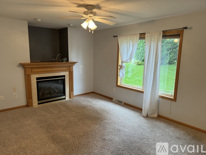 A living room with a fireplace and a flat screen TV mounted above it.