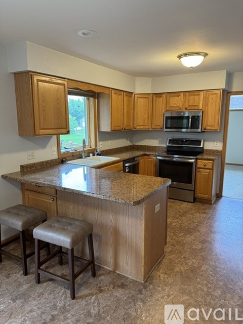 A kitchen with wooden cabinets and a granite countertop.
