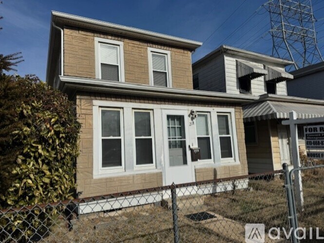 A house with a sign that says "FOR RENT" in front of it.