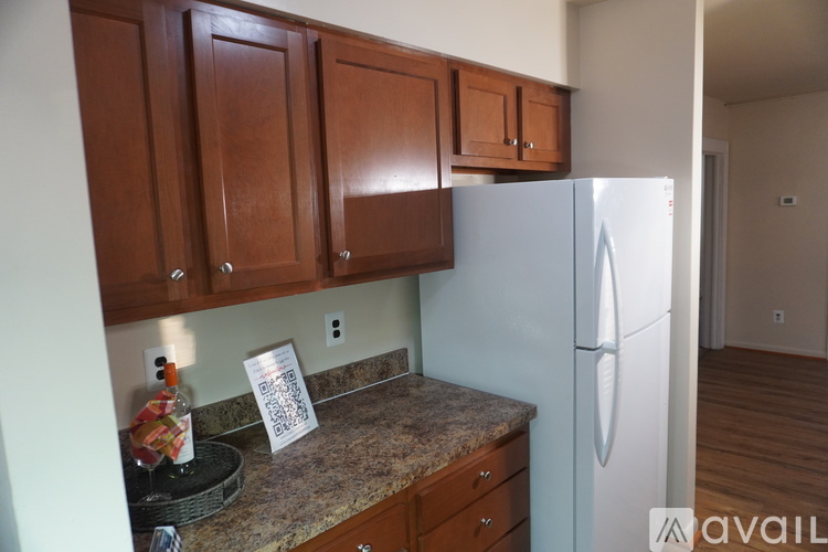 A kitchen with brown cabinets and a white refrigerator.