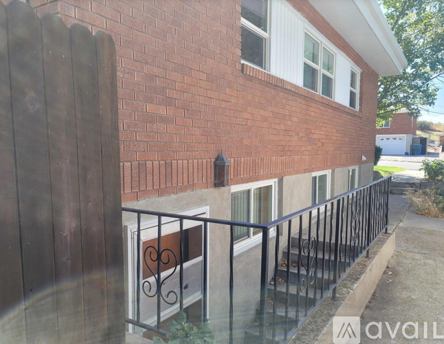 A red brick house with a black iron fence.