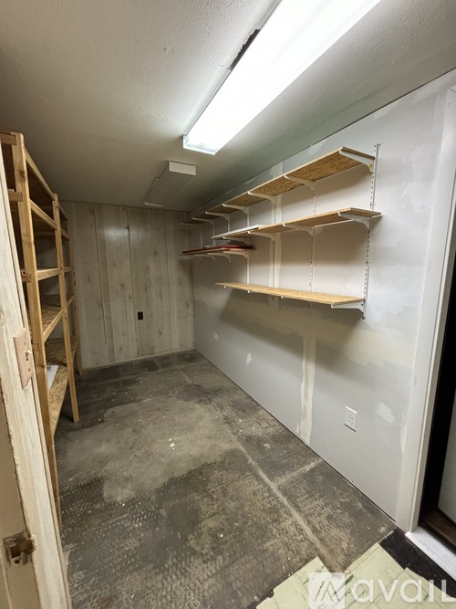 A room with a ladder and shelves is under construction.