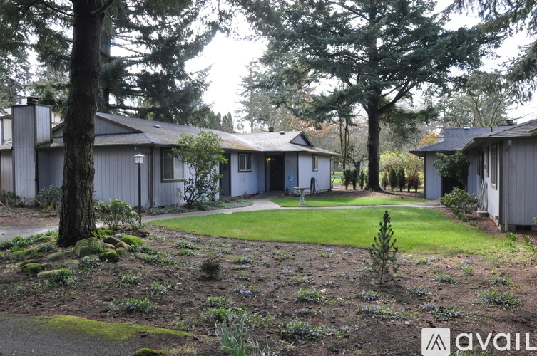A house with a lawn and trees in front of it.