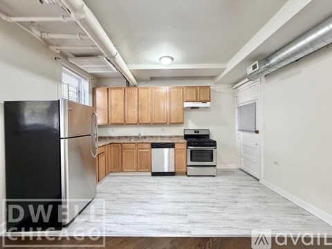 A kitchen with wooden cabinets and a stainless steel refrigerator.