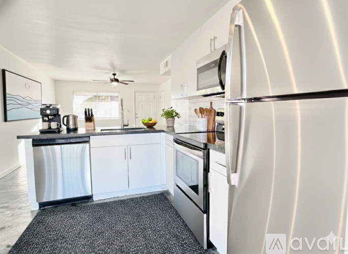 A kitchen with a refrigerator, microwave, and oven.