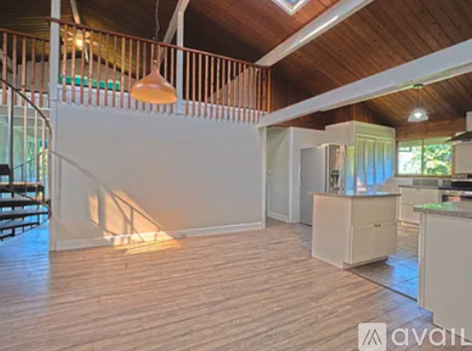 A living room with wooden floors and a staircase.