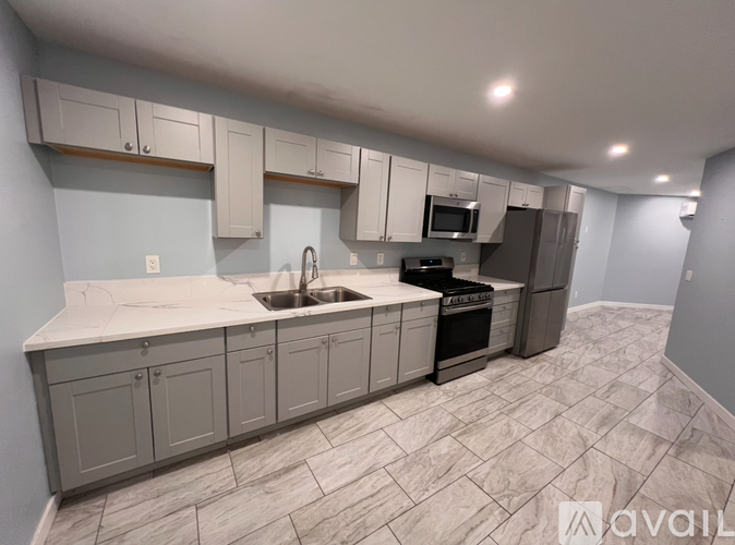 A kitchen with a sink, stove, and cabinets.