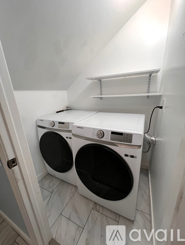 A white washing machine and dryer in a small laundry room.