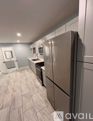A kitchen with a refrigerator, sink, and oven.