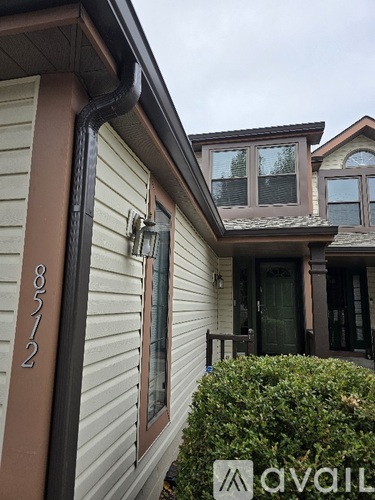 A house numbered 8727 is shown with a large bush in front.