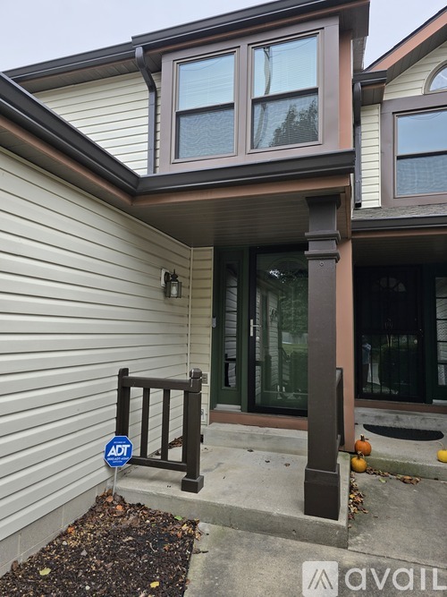 A house with a brown column and a sign that says ADT.