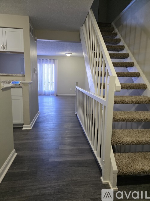 A staircase with a carpeted runner and white railings.