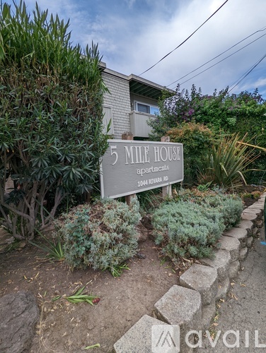 A sign for 5 Mile House apartments is in front of a building.