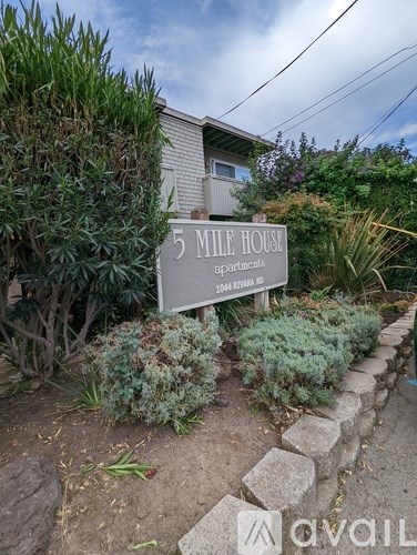 A sign for 5 Mile House apartments is in front of a building.