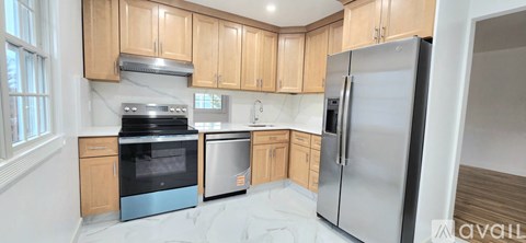 A kitchen with wooden cabinets and a stainless steel refrigerator.