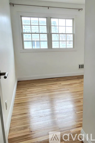 A room with a window and wooden flooring.