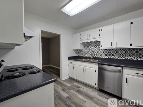 A kitchen with white cabinets and a black stove top.