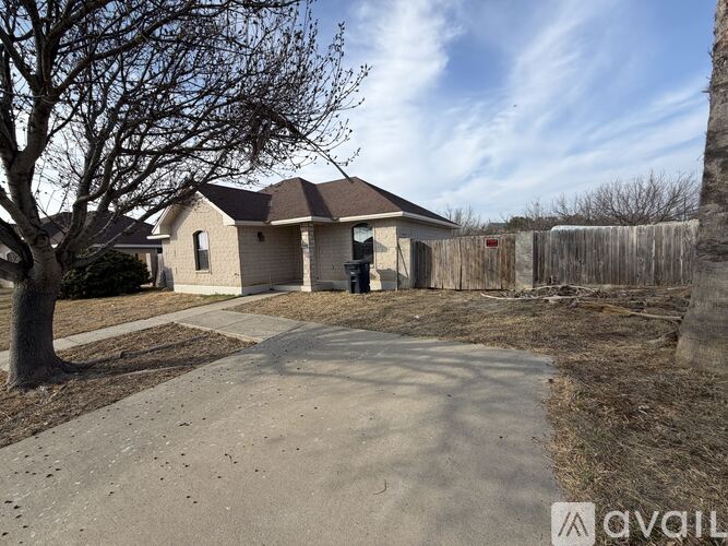 A house with a driveway and a tree in front of it.