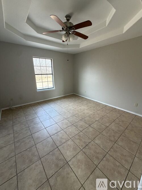 A room with a ceiling fan and tiled floor.