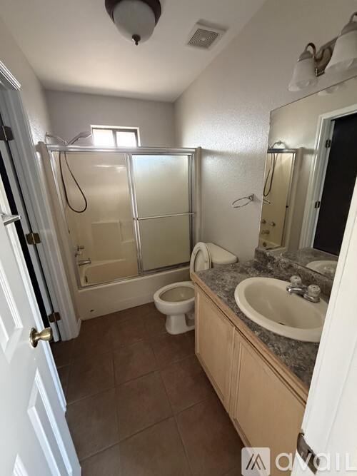 A bathroom with a toilet, sink, and shower.