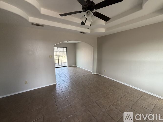 A room with a ceiling fan and tiled floor.