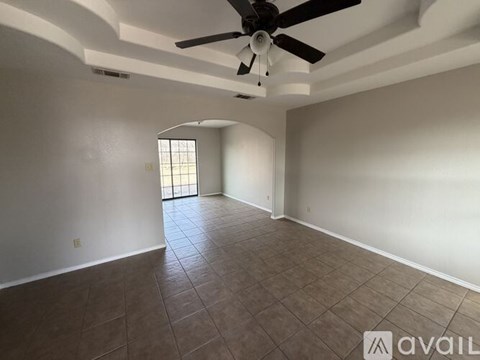 A room with a ceiling fan and tiled floor.