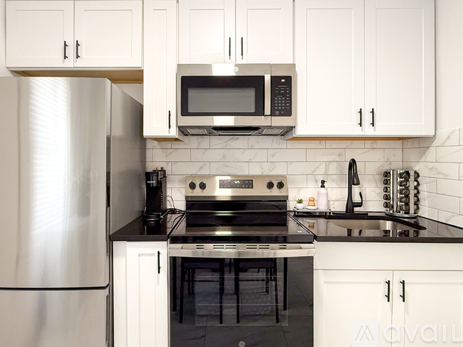 A modern kitchen with white cabinets and stainless steel appliances.