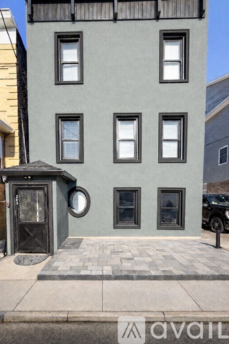 A grey building with a black door and windows.