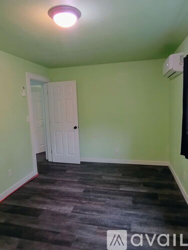 A room with a door and a wall-mounted air conditioner unit.