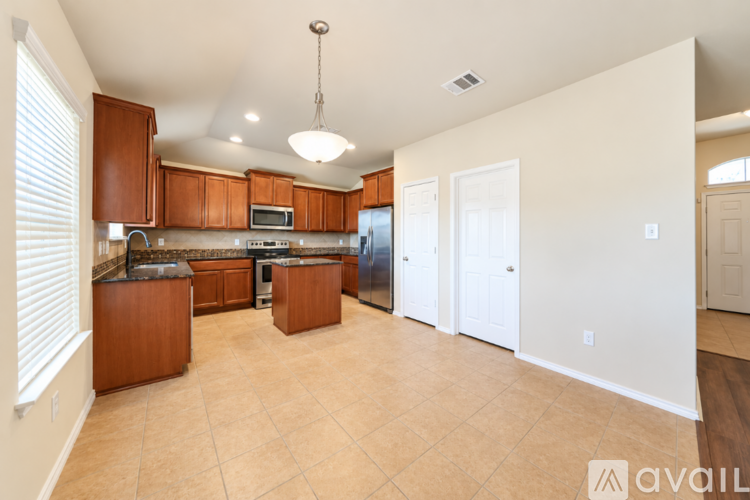 A kitchen with wooden cabinets and a tiled floor.