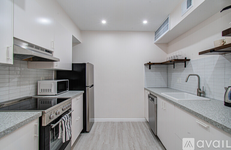 A kitchen with white cabinets and a black stove top oven.