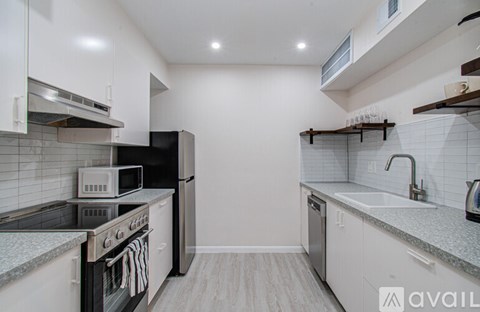 A kitchen with white cabinets and a black stove top oven.