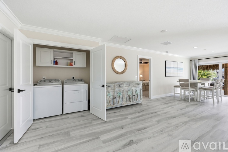 A modern kitchen with white appliances and a wooden floor.