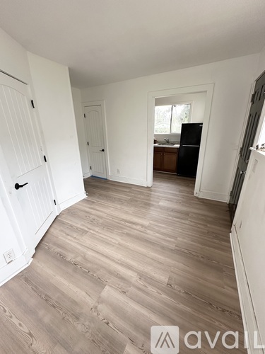 A room with wooden flooring and white walls.