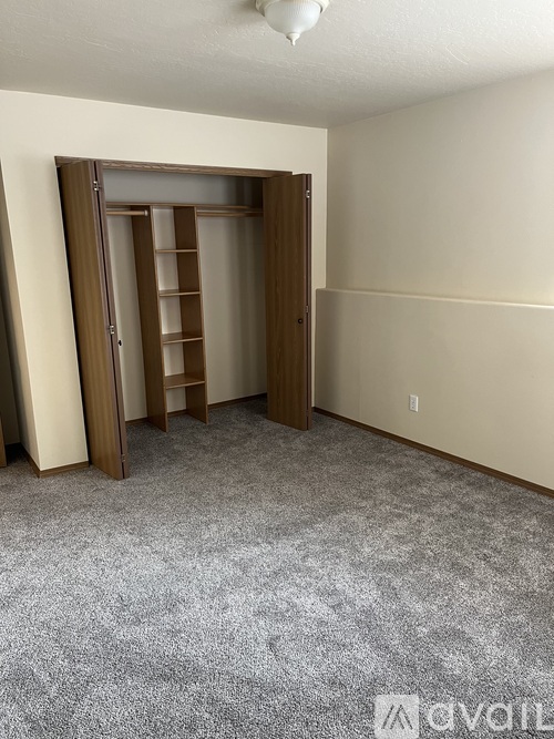 A room with a carpeted floor and a wooden door.
