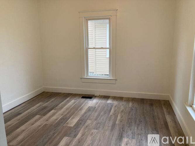 A room with a window and wooden flooring is available for rent.