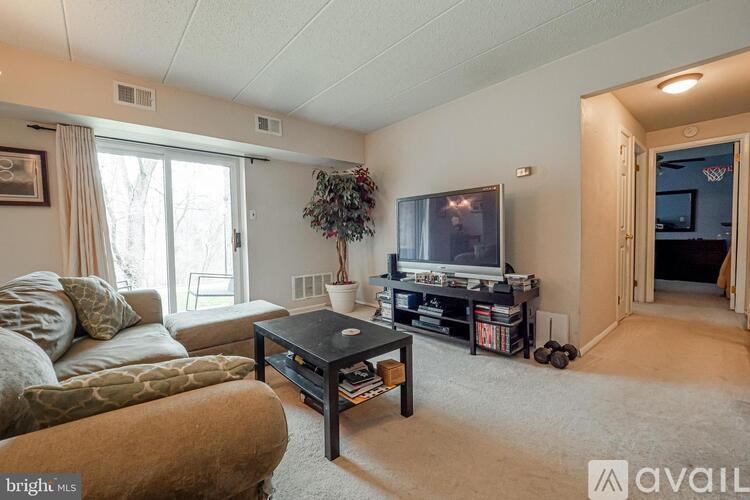 A living room with a couch, a coffee table, and a television.
