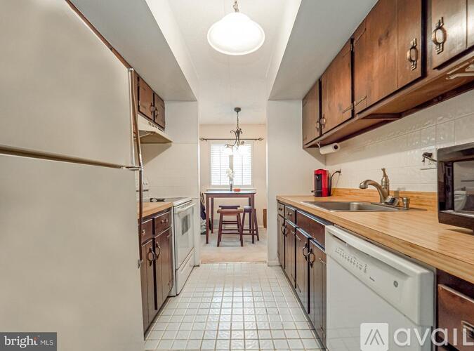 A kitchen with wooden cabinets and a white fridge.