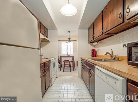 A kitchen with wooden cabinets and a white fridge.