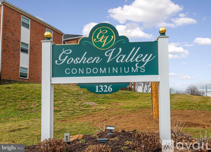 A sign for Goshen Valley Condominiums stands in front of a building.