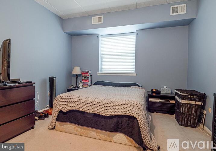 A bedroom with a bed, dresser, and window.