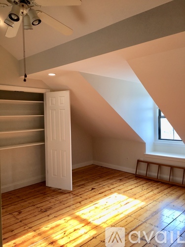A room with a ceiling fan and wooden floors.