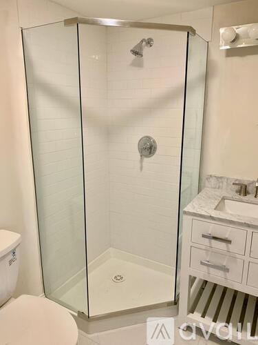A white bathroom with a walk in shower and toilet.