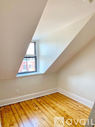 A room with wooden flooring and a window.